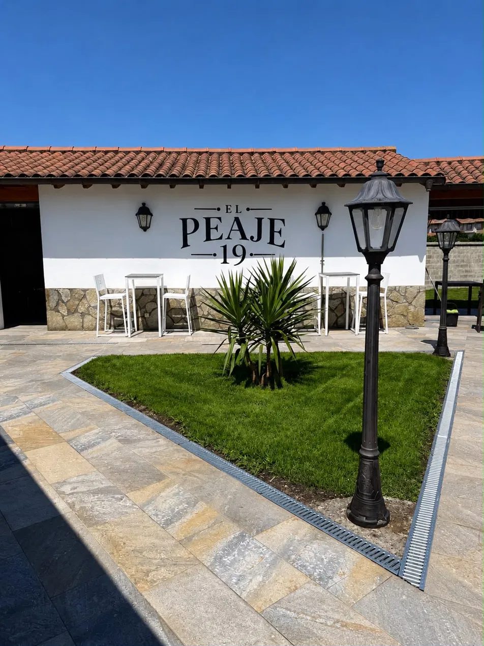 Fachada lateral con el rótulo pintado y el jardín