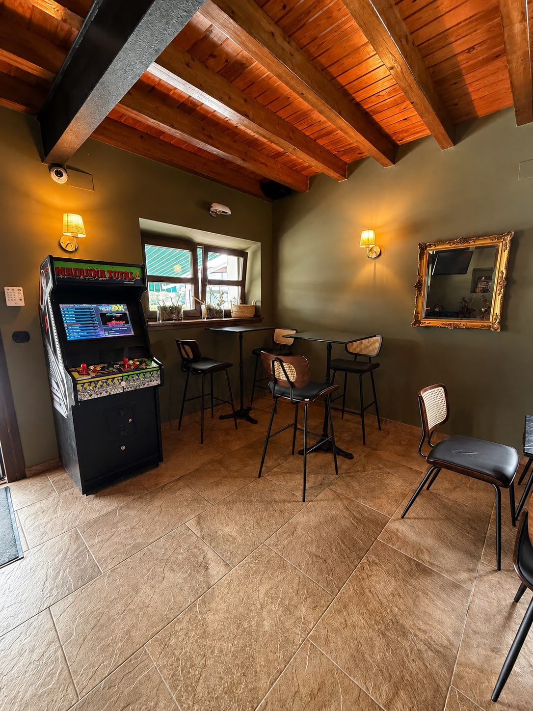 Máquina arcade recreativa junto a las mesas altas